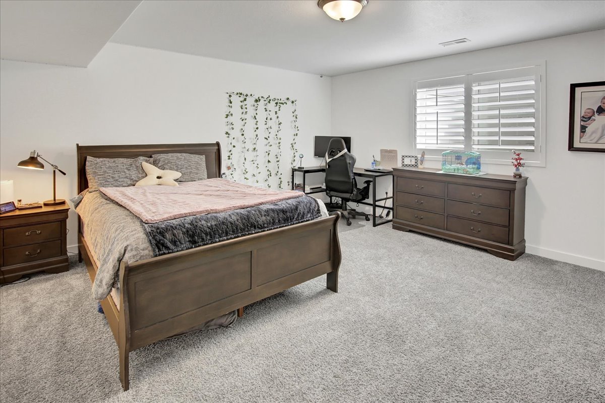 Bedroom featuring light carpet and an office area
