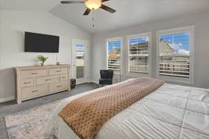 Bedroom with light colored carpet, access to exterior, lofted ceiling, and a ceiling fan