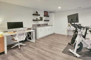 Office space featuring light wood-style flooring and recessed lighting
