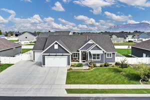View of front of property featuring board and batten siding, roof with shingles, concrete driveway, a residential view, and an attached garage