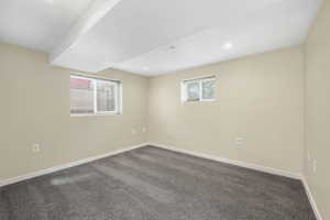 Basement featuring dark colored carpet and recessed lighting