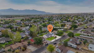 Aerial view of residential area with a mountainous background and property parcel outlined