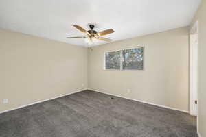 Spare room featuring carpet flooring and ceiling fan