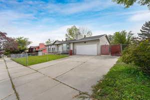 Single story home with driveway, a garage, a chimney, and a gate