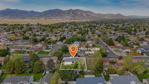 Aerial perspective of suburban area featuring a mountainous background and property parcel outlined