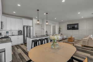 Dining space with recessed lighting, a decorative wall, and dark wood-type flooring