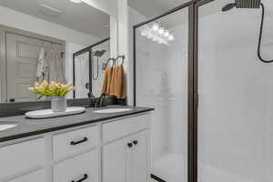 Full bathroom with a shower stall and double vanity