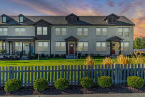 View of front of property featuring stucco siding, a fenced front yard, and roof with shingles