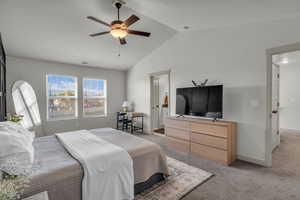 Carpeted bedroom featuring vaulted ceiling, a ceiling fan, ensuite bath, and a textured ceiling