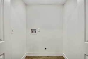 Washroom with wood finished floors, hookup for a washing machine, and hookup for an electric dryer