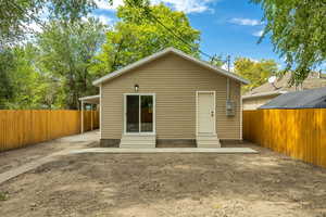 Back of house with entry steps and a fenced backyard