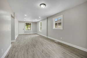 Spare room with light wood-type flooring, a textured ceiling, and recessed lighting