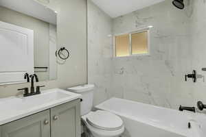 Full bath featuring vanity and washtub / shower combination