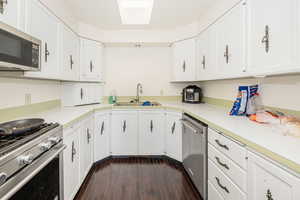 Kitchen with appliances with stainless steel finishes, light countertops, and white cabinetry