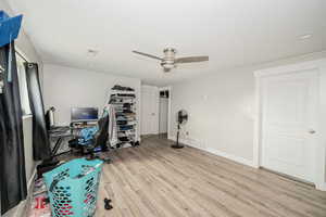 Office with light wood-style floors, a textured ceiling, and ceiling fan