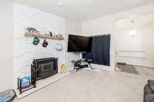 Carpeted living room featuring a fireplace and baseboards