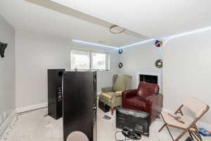 Living area with a textured ceiling and unfinished concrete flooring