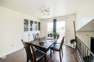 Dining space featuring dark wood-style floors, a textured ceiling, and a chandelier