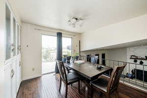 Dining space with dark wood-type flooring, a textured ceiling, and a fireplace