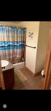Bathroom featuring vanity, shower / tub combo, and light tile patterned floors
