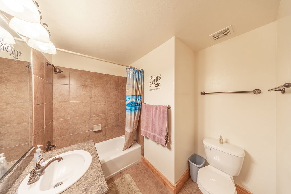Full bath with vanity, light tile patterned floors, and shower / tub combo