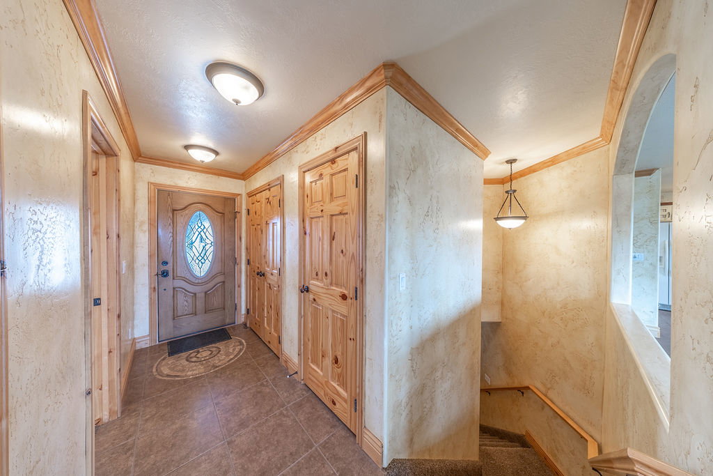 Foyer with ornamental molding and dark tile patterned flooring