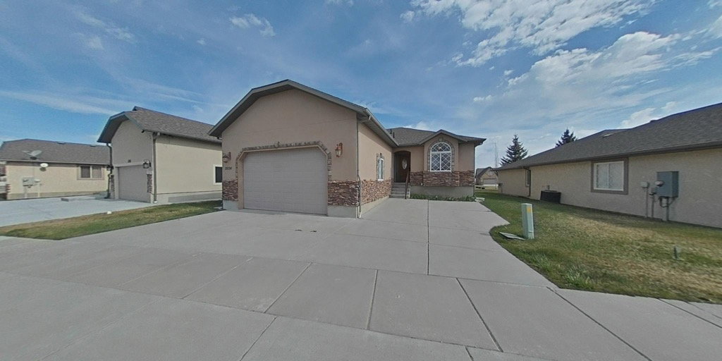 Single story home featuring stucco siding, a garage, concrete driveway, and a front yard