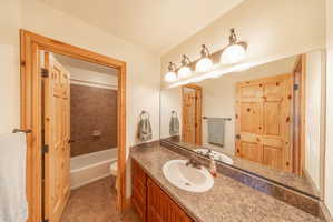 Bathroom featuring vanity, light tile patterned floors, and bathtub / shower combination