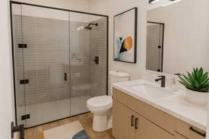 Bathroom featuring vanity, light wood-style floors, and a stall shower