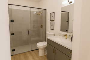 Bathroom featuring vanity, a stall shower, and light wood-style flooring