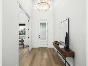 Foyer featuring a chandelier, a high ceiling, and wood finished floors