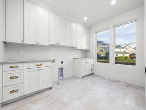 Laundry area with hookup for an electric dryer, recessed lighting, cabinet space, washer hookup, and a mountain view
