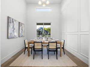 Dining space with suspended lighting, healthy amount of natural light, wood finished floors, and a high ceiling