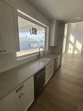 Kitchen featuring white cabinetry, dishwasher, and dark wood-style floors