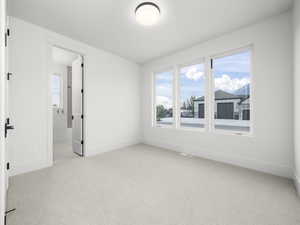 Spare room with light colored carpet and baseboards