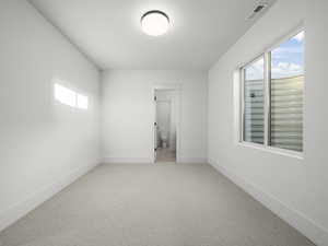 Unfurnished room featuring light colored carpet and baseboards