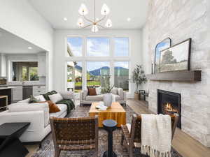 Living room featuring a mountain view, a high ceiling, wood finished floors, a fireplace, and suspended lighting