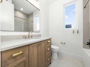 Bathroom featuring vanity, light tile patterned floors, and tub / shower combination