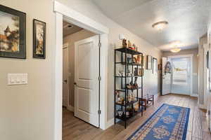 Hallway featuring a textured ceiling and wood tiled floors