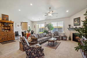 Living room featuring a tile fireplace, ceiling fan, vaulted ceiling, and recessed lighting