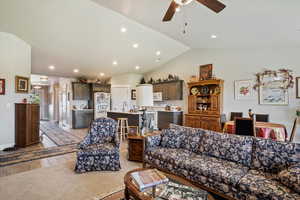 Living area featuring vaulted ceiling, ceiling fan, recessed lighting, and light wood-style floors