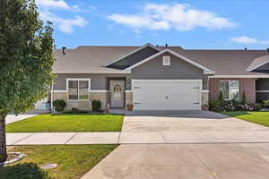 Single story home with roof with shingles, stone siding, driveway, and stucco siding