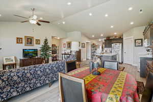 Dining space featuring wood finish floors, high vaulted ceiling, recessed lighting, and a ceiling fan
