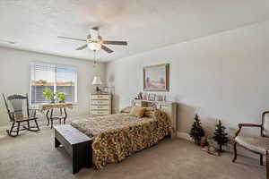 Carpeted bedroom with a textured ceiling and a ceiling fan