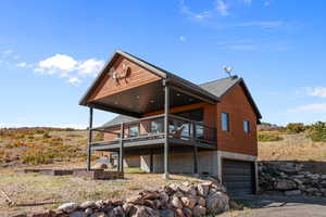 Back of house with a garage and a wooden deck