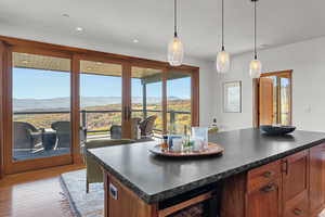 Kitchen with dark countertops, a mountain view, decorative light fixtures, brown cabinets, and recessed lighting