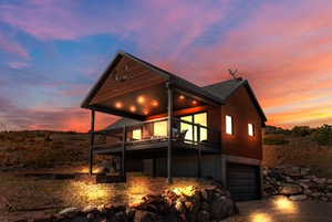 Back of house featuring an attached garage and driveway