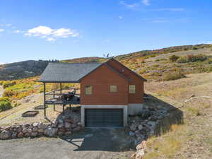 View of side of property with driveway, an attached garage, and a wooden deck