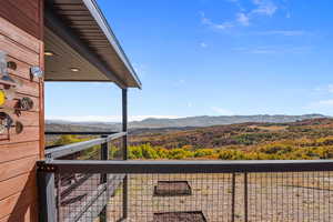 Balcony featuring a mountain view and a wooded view