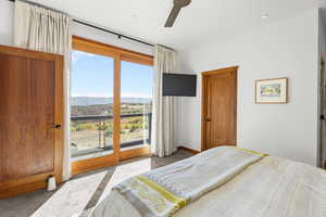 Carpeted bedroom featuring access to outside and ceiling fan